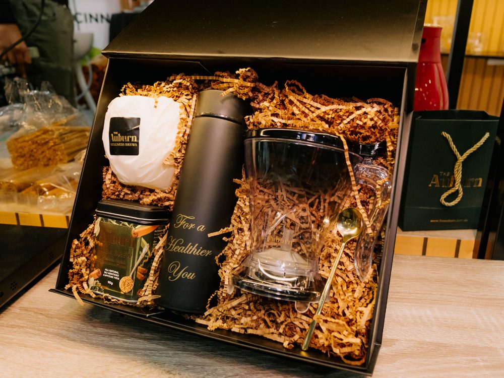 An Auburn gift box with flask, glass, tin and gold spoon