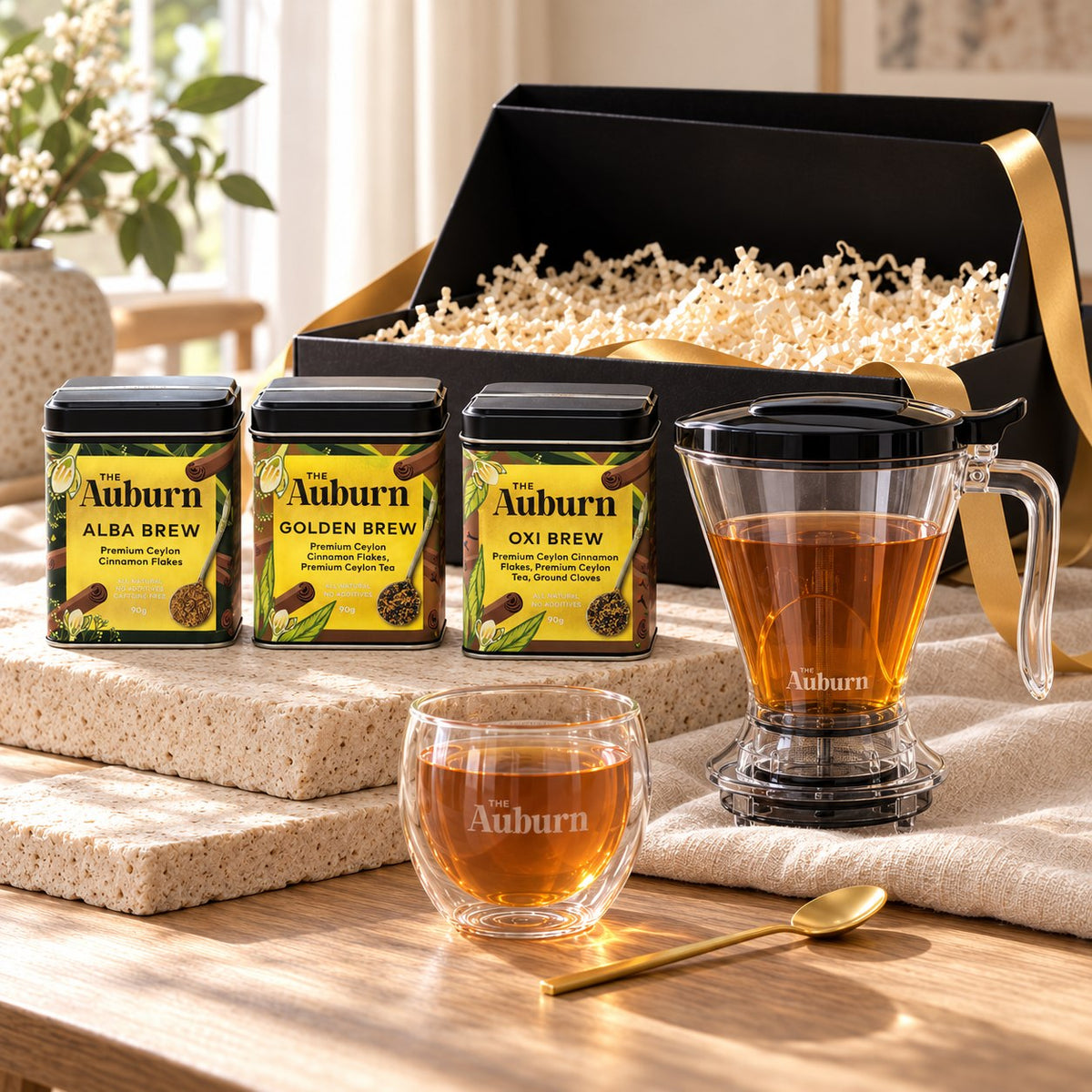 BREWER'S way hamper: Alba, Oxi and Golden Brew tins, a brew maker jug, a glass mug and a gold tea spoon.