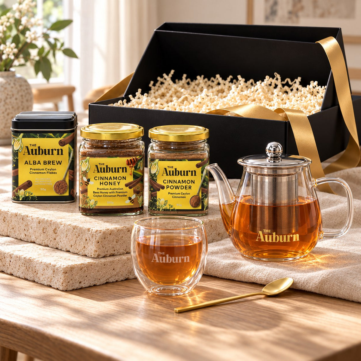 It's a CELEBRATION hamper: an Alba Brew tin, jars of cinnamon honey and powder, a glass teapot, a glass mug and a gold tea spoon.
